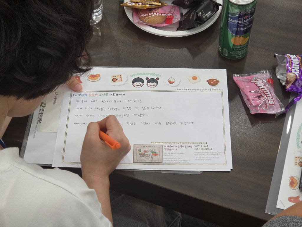 GOLFZON Reinforces ESG Commitment Through Employee-Led Environmental and Community Initiatives 4 GOLFZON employee writes a message of encouragement for children supported through the companys meal support program in partnership with Good Neighbors